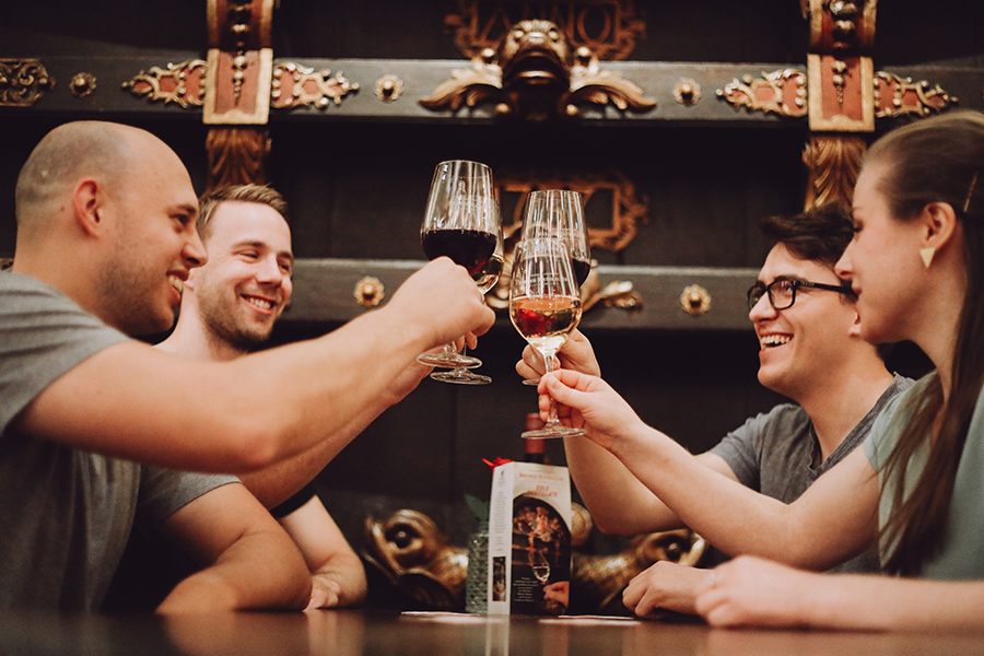 Eine Gruppe stößt mit einem Glas Wein an im Ratskeller in Bremen