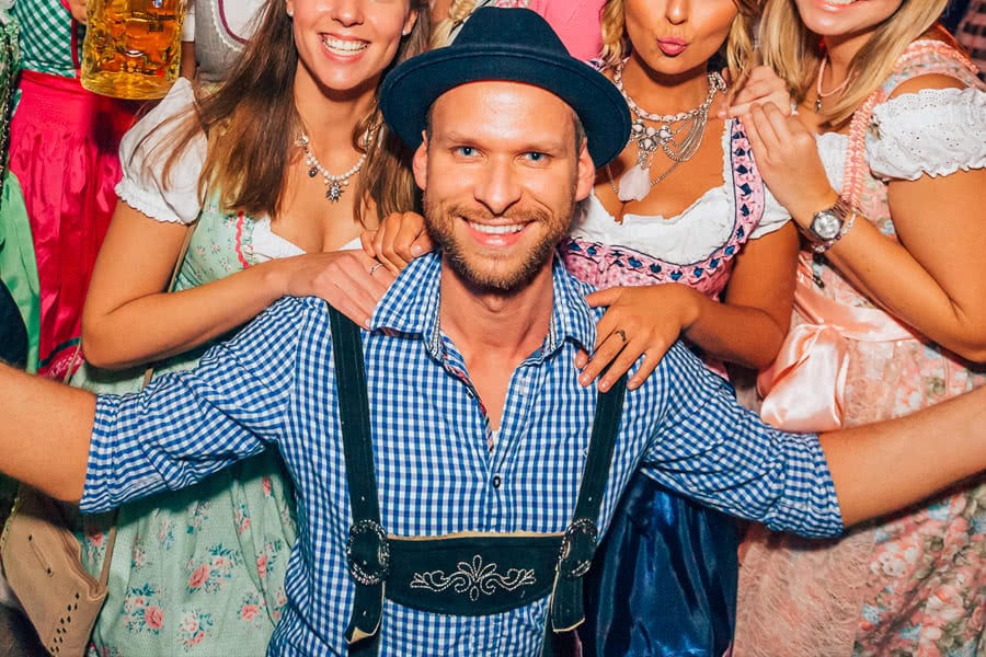Mann in Tracht umgeben von Frauen im Dirndl auf dem Oktoberfest Münster